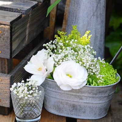 Inspiración para colocar la tarta en una boda rústica: os damos ideas para un montaje muy sencillo con cajas de madera y regaderas vintage de zinc.