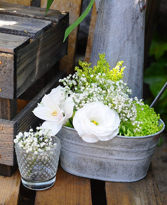 Inspiración para colocar la tarta en una boda rústica: os damos ideas para un montaje muy sencillo con cajas de madera y regaderas vintage de zinc.