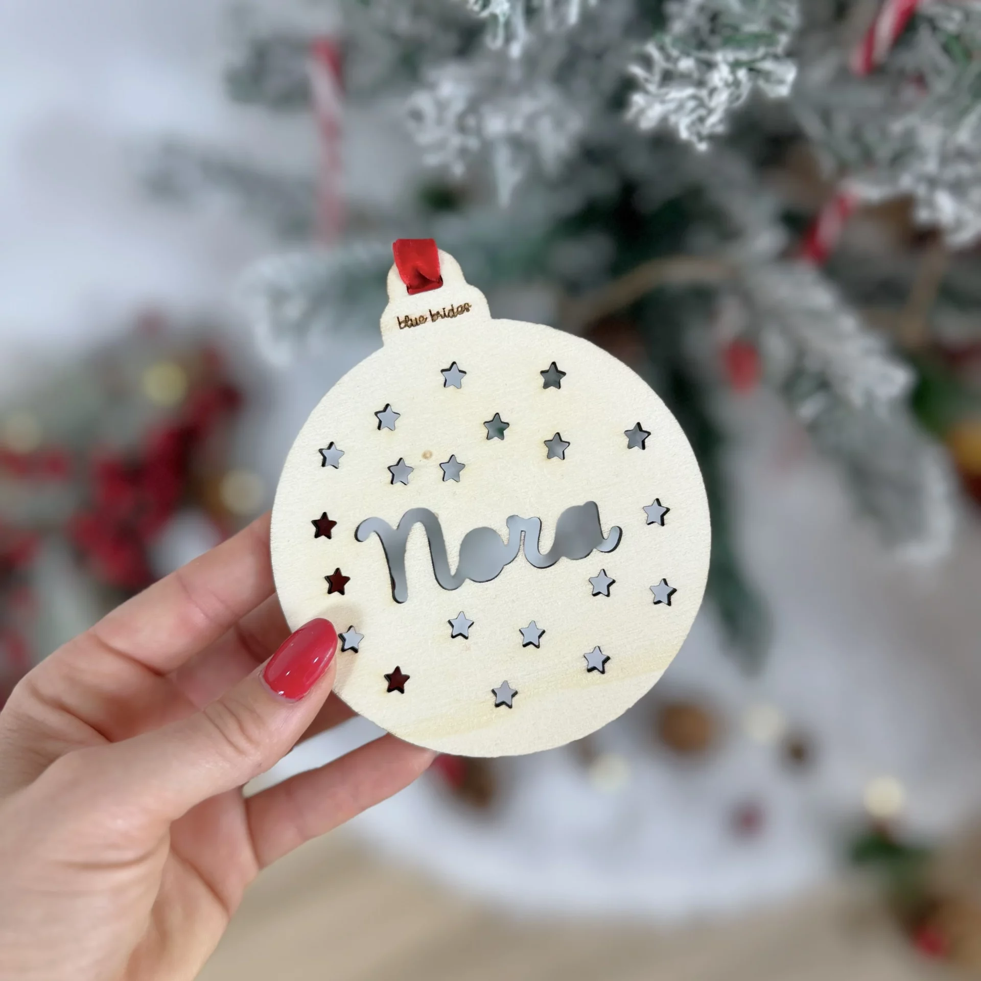 Adorno navideño de madera con estrellas caladas y nombre en relieve