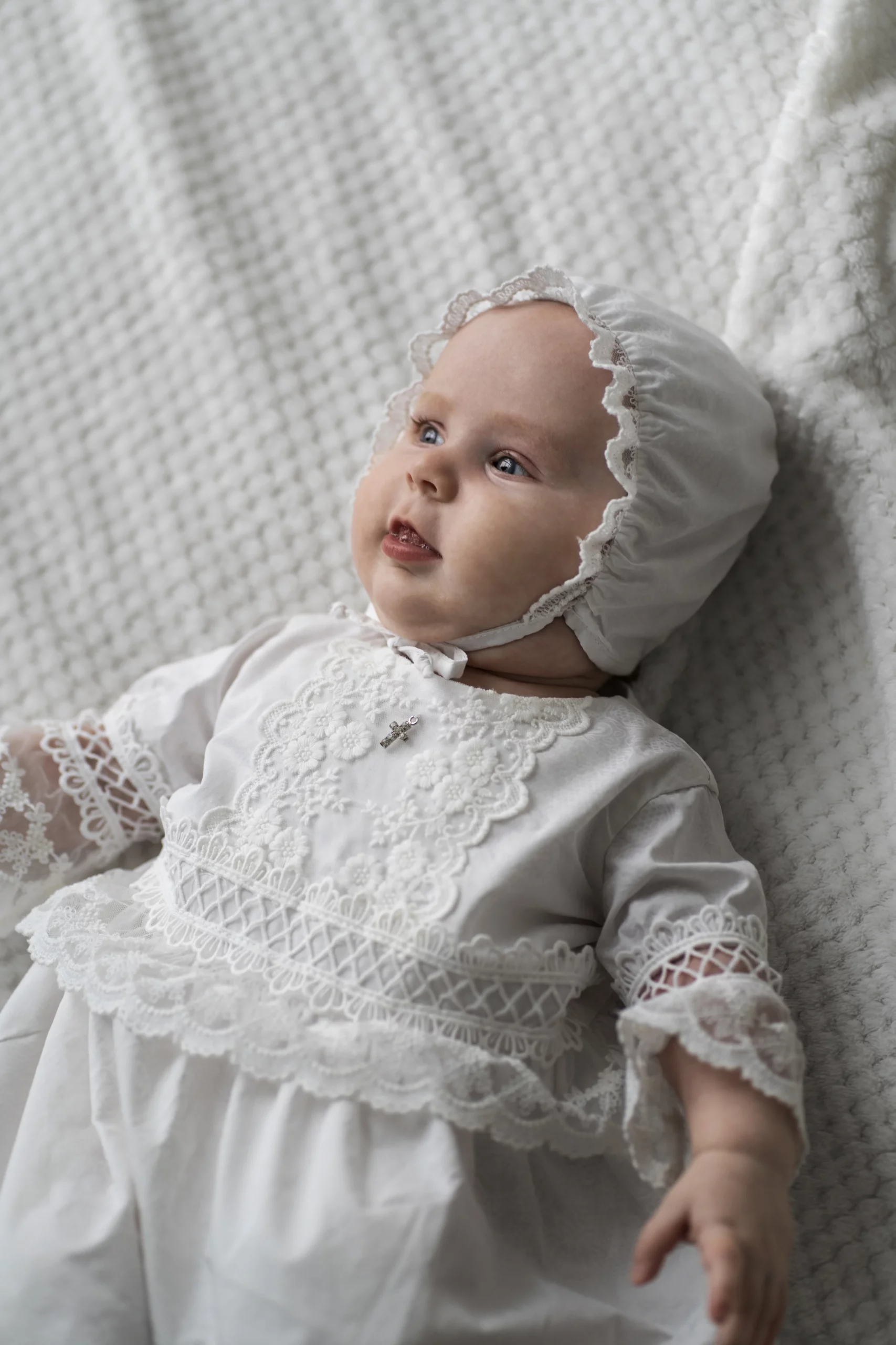 Bebe con traje blanco tradicional para bautizo
